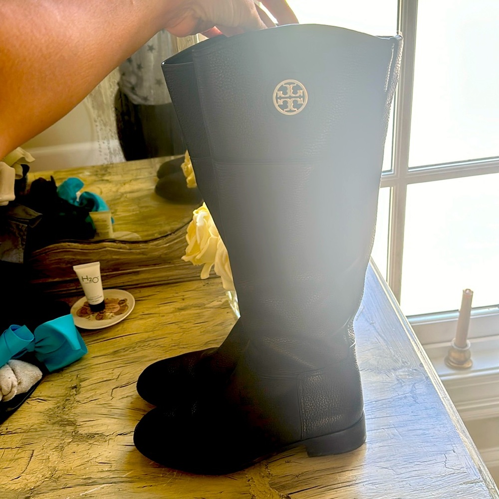 Black leather Tori Burch boots underneath the knee.
